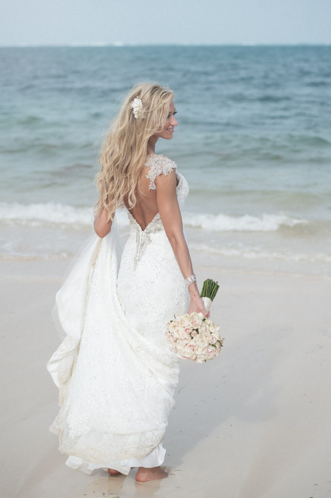 Alyssa on the beach in her wedding dress at Dreams Resort Cancun Mexico