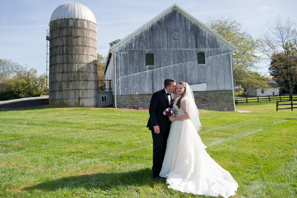 spencer kisses jeanette in front of the barn at Crown Rose Estate
