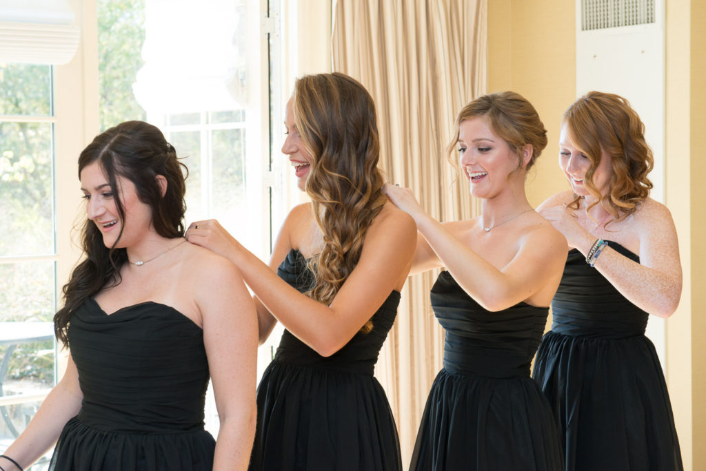Michelels bridemaids help each other get ready at The Salamander Resort Wedding