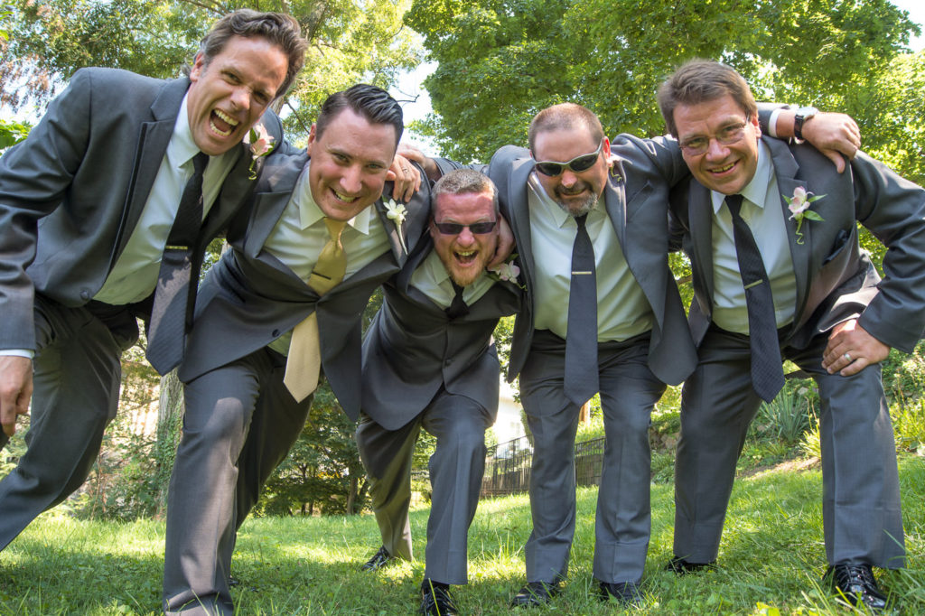 Chris and his groomsmen hugging shot from a low angle