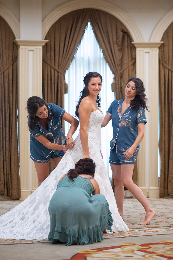 Bridesmaids getting Darian into the wedding dress before her wedding at Woodholme Country Club